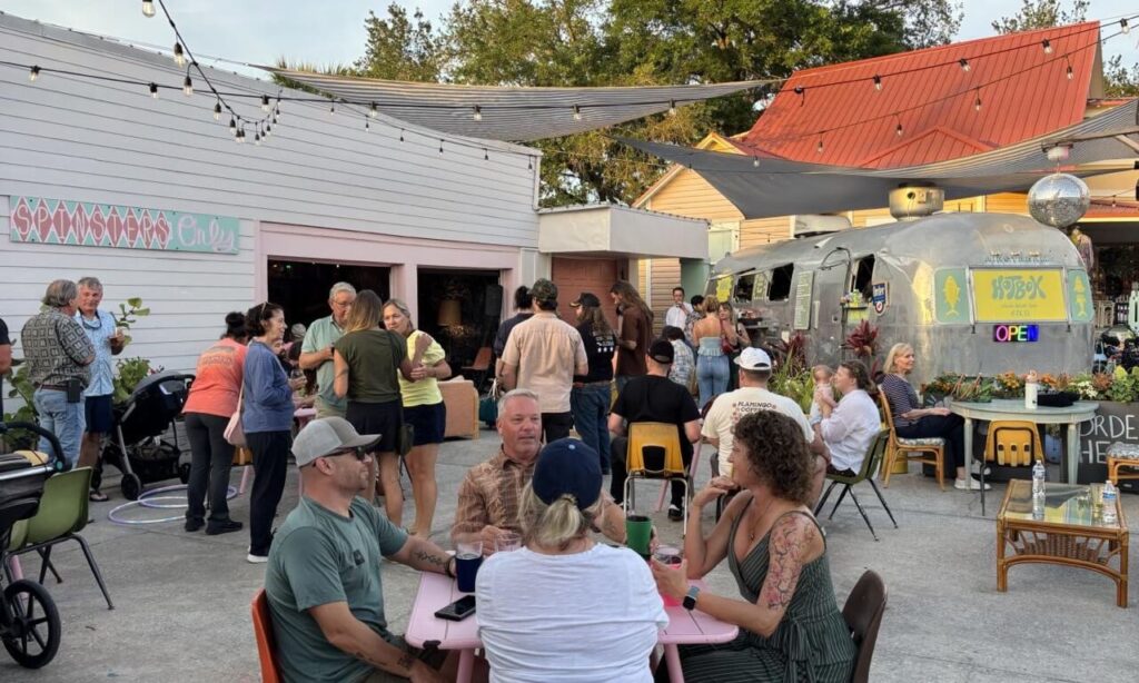 Several people sitting at tables talking with one another.