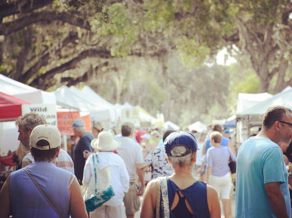 People, white tents and live oak trees at St. Augustine Farmers Market