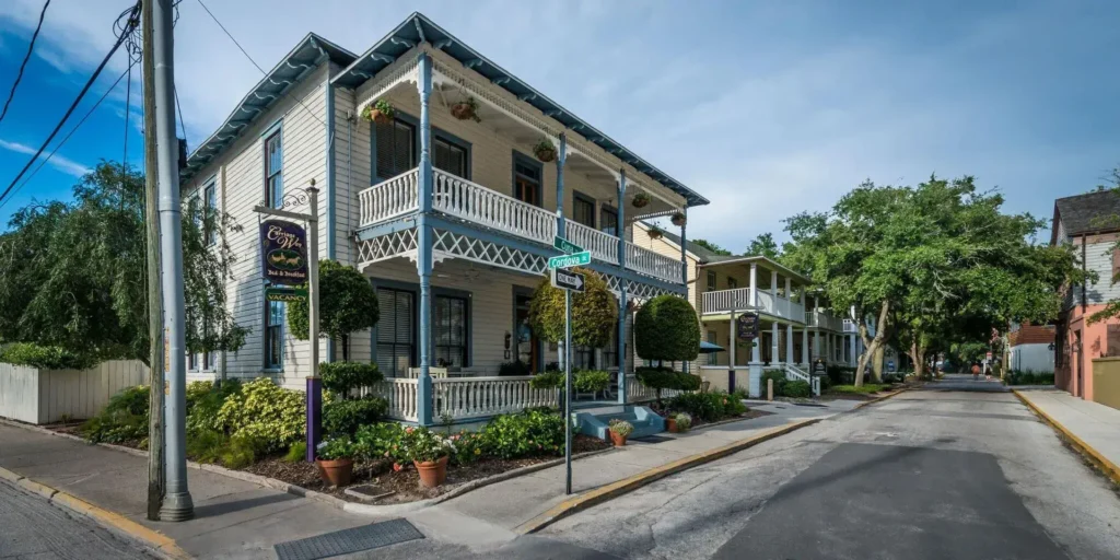 Large blue and white building on a street with foliage, The Carriage Way Inn, St. Augusitne, FL